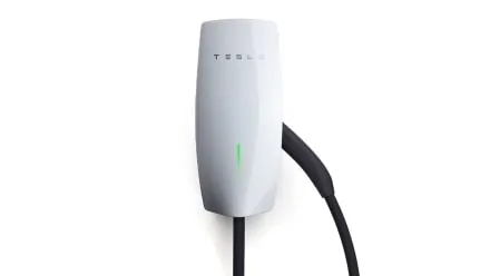 Tesla Gen 3 Wall Connector mounted on a wall with its charging cable coiled below.